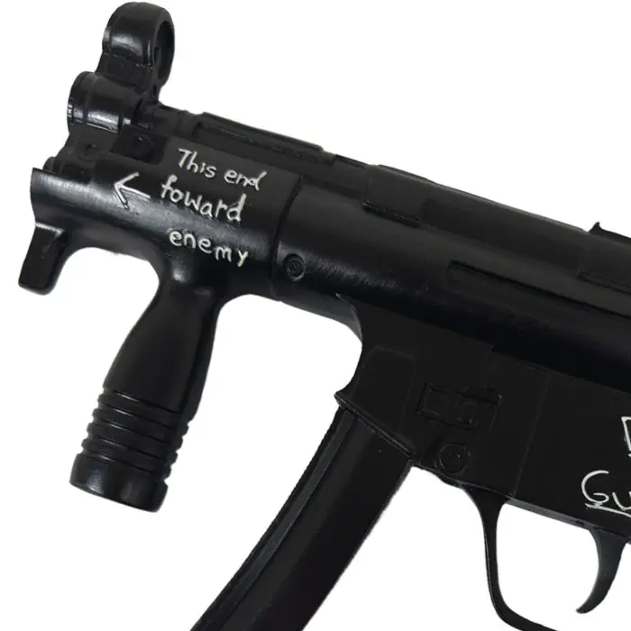 Pistola de Deadpool en primer plano, con la inscripción «this end forward enemy» en la mira